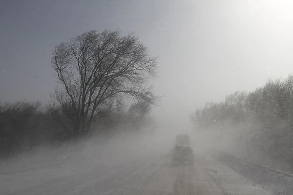 Vehicles drive along a snowy road near the Russian southern city of Stavropol