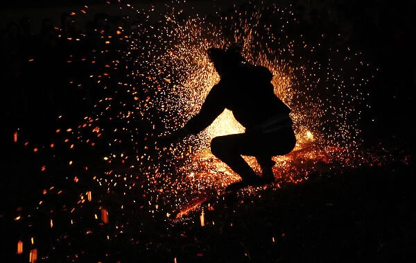 A Vietnamese man from the Pa Then minority group jumps into a fire during a ritual