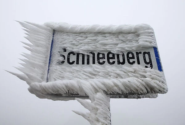 A village sign is covered with ice in Schneeberg