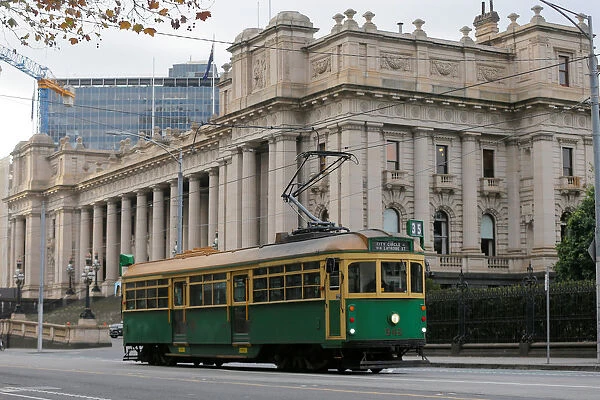 A vintage Melbourne tram passes by Victorias Parliament Building in Melbourne