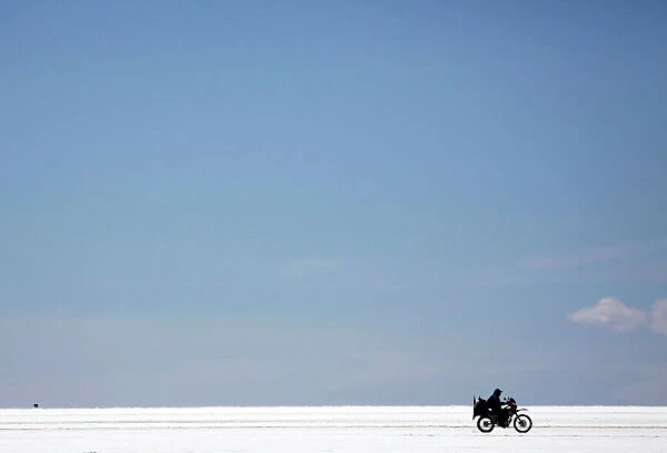 A visitor on a bike rides on the salt flat during the eighth stage of the Dakar Rally