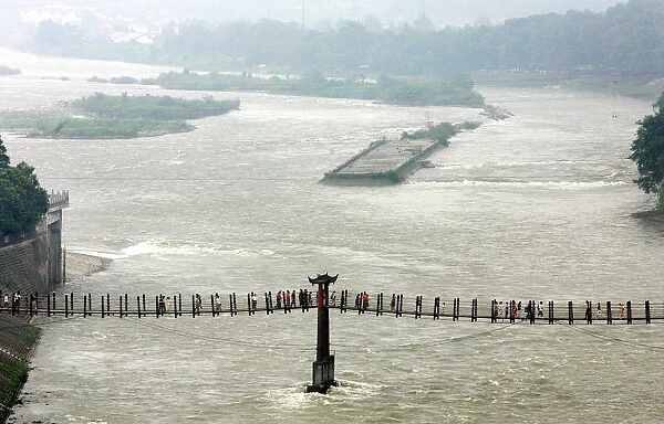 Visitors cross a cable bridge over Minjiang River in Chinas Dujiangyan
