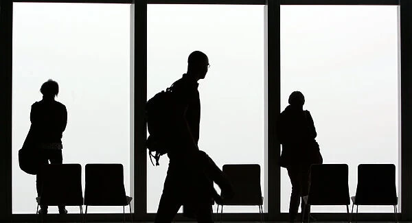 Visitors is silhouetted against a cloudy sky on the observation deck of a skyscraper