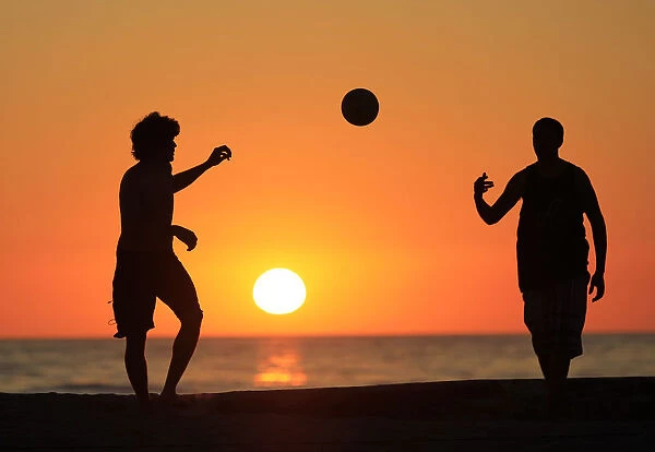 Volleyball players change serve as the sun sets at Moonlight Beach in Encinitas
