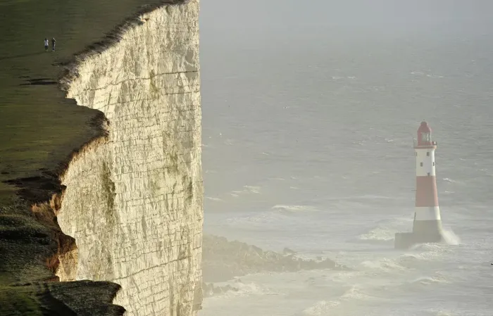 Framed Print : Walkers look out over Beachy Head lighthouse and heavy seas in the English Channel Framed Print : Walkers look out over Beachy Head lighthouse and heavy seas in the English Channel