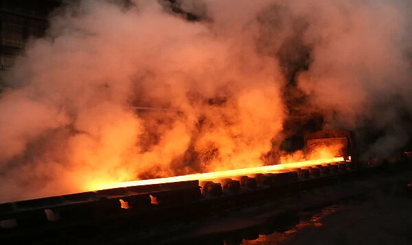 Water runs off a steel coil as it is unrolled on the line at the Novolipetsk Steel PAO