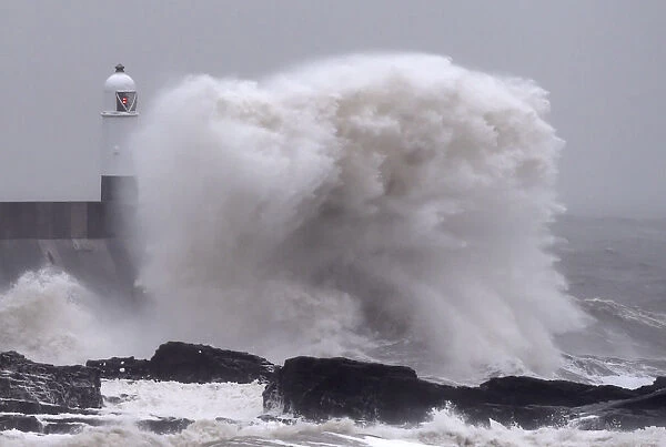 Waves crash over the harbour wall as gale force winds hit Porthcawl in south Wales
