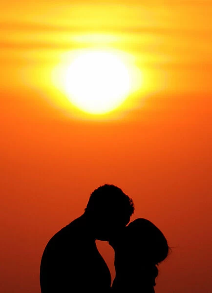 Western tourists kiss during sunset in Bali