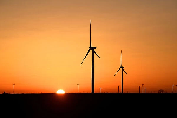 Wind turbines operate at sunrise in the Permian Basin oil