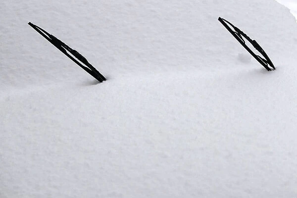 Windscreen wipers of a snow-covered car are seen in Bucharest