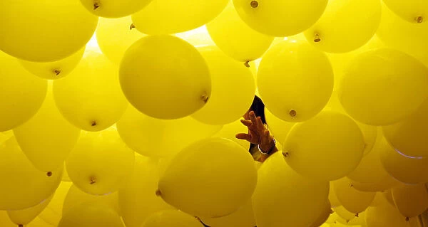 A woman arranges balloons to be released into the skies above Sao Paulo downtown during