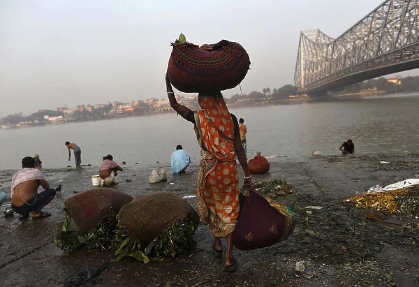 A woman carries sacks of leaves, which will be used to decorate flower bouquets, to