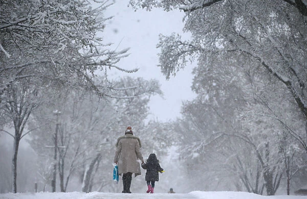 A woman and child walk along the side of the National Mall in Washington