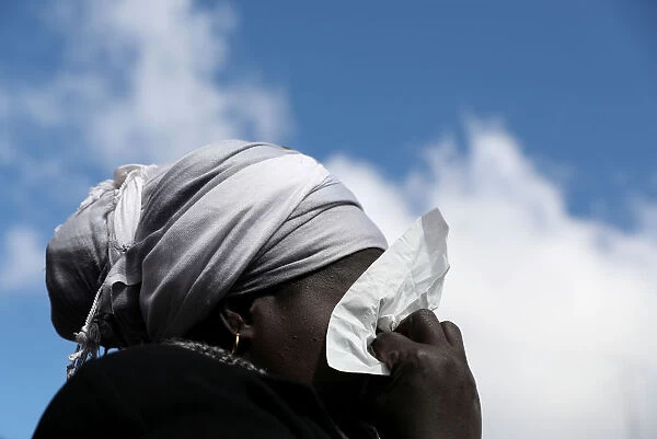A woman cries as she attends a gathering to protest the death of a street hawker in