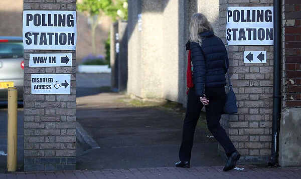 A woman enters a polling station as voting begins in local government elections in London