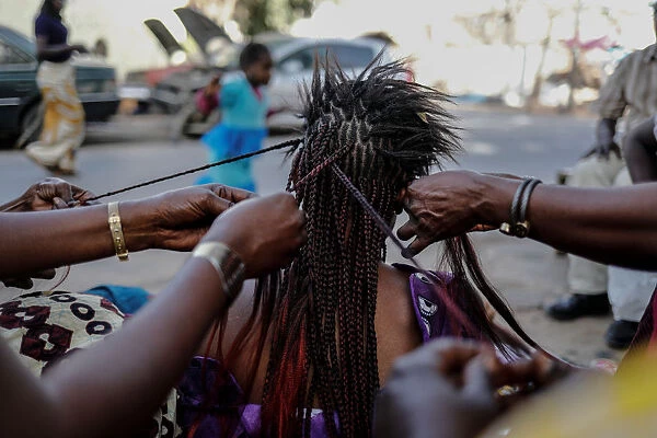 A woman gets her hair plaited at the Medina in the capital Dakar