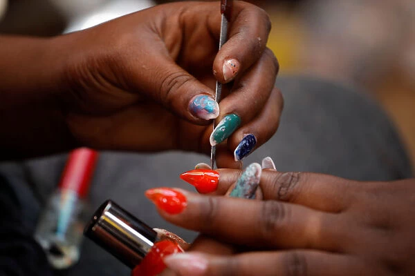A woman gets a manicure at a street stand in Port-au-Prince