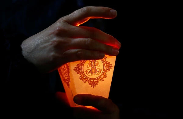 Woman holds a candle during the annual Icon of the Mother of God procession in the