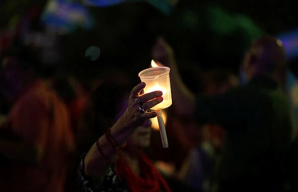 A woman holds a candle during a protest against utility rate hikes in Buenos Aires
