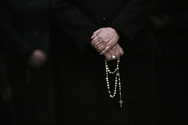 A woman holds her rosary during a Holy Week procession in Madrid