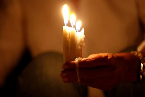 A woman lights candles during a candlelight vigil in solidarity with the Jordanian