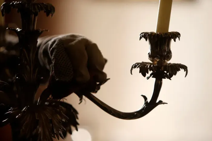 Framed Print : A woman polishes an antique silver candelabra at her home in Valletta