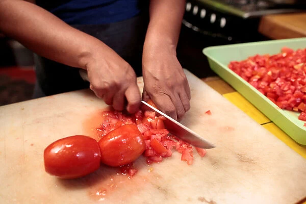 A woman prepares tomato sauce in her kitchen at the colonial city of Granada, Nicaragua