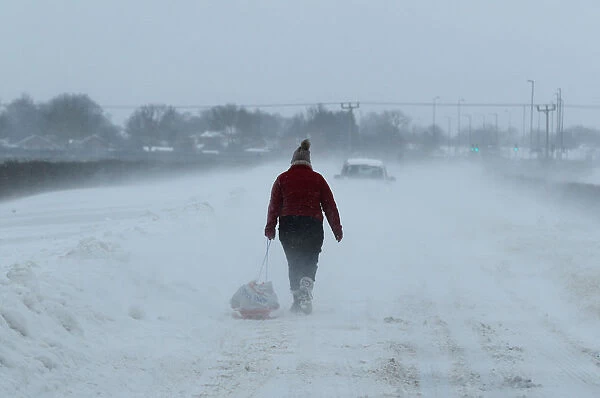 A woman pulls shopping on a sledge near Lincoln