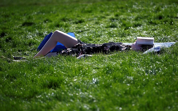 A woman relaxes in the sunshine on Primrose Hill in north London