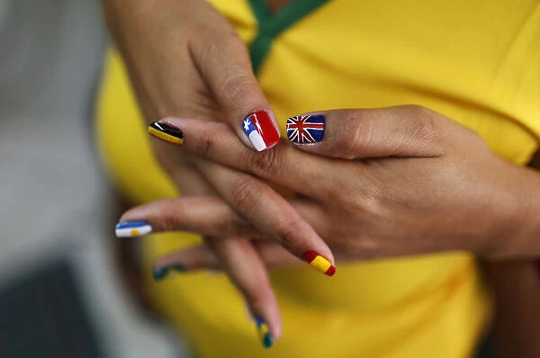 A woman shows her nails after being painted with the flags of countries that will