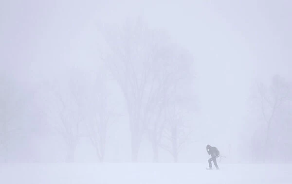 A woman snowshoes on the Plains of Abraham during a snowstorm in Quebec City