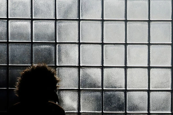 A woman stands bundled up from the cold outside a bus terminal in Queens, New York