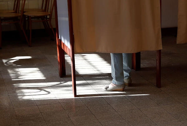A woman stands in polling booth during Hungarian parliamentary elections at a polling