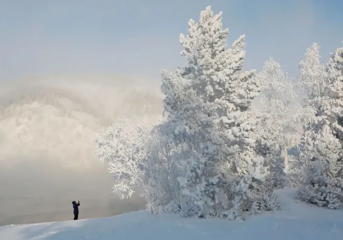 Framed Print : A woman takes pictures on a bank of the Yenisei River covered with snow and hoarfrost Framed Print : A woman takes pictures on a bank of the Yenisei River covered with snow and hoarfrost