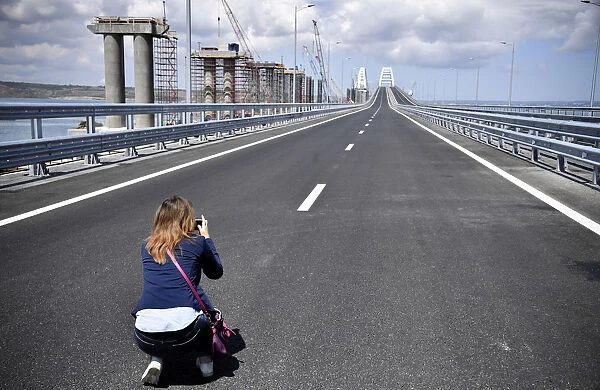 A woman takes pictures prior to a ceremony opening a bridge