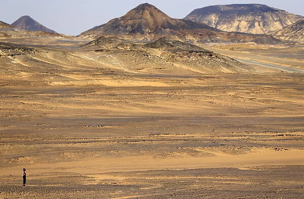 A woman walks through the Black Desert near the Bahariya Oasis southwest of Cairo