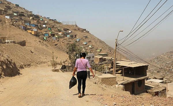 A woman walks at a hill in the shanty town Nueva Esperanza on the outskirts of Lima