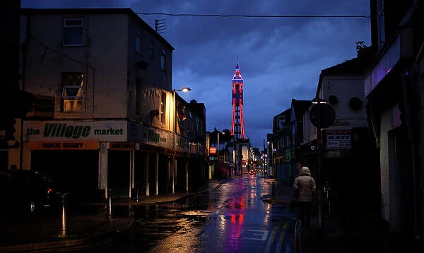 A woman walks down a side road towards the Tower in Blackpool