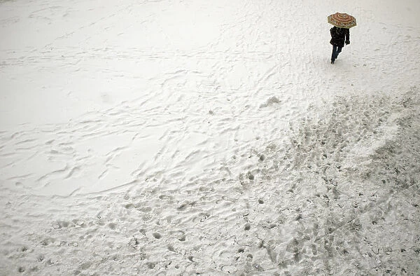 Woman walks with umbrella during snowfall in downtown Sofia