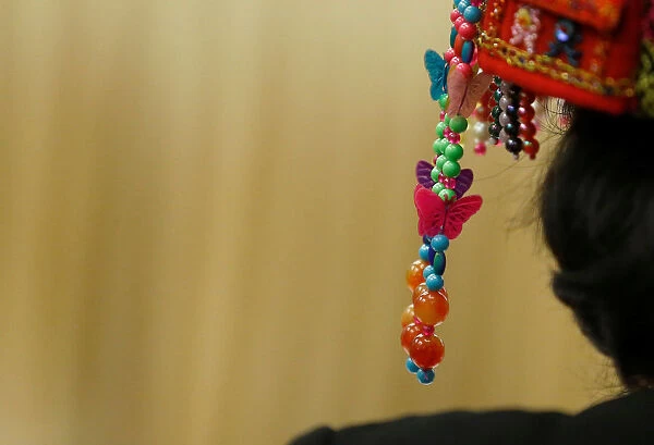 A woman wears traditional headgear during a session of the Hainan province at the