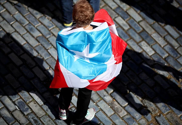 A woman is wrapped in a national flag during a protest demanding that authorities fix the