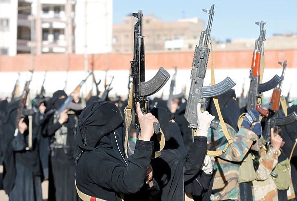 Women loyal to the Houthi movement hold up rifles as they attend a gathering to show