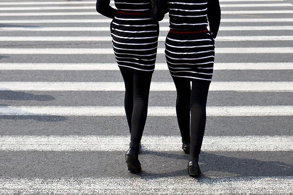 Women walk on a pedestrian cross in central Shanghai