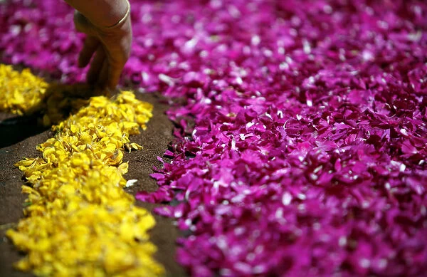 A worker adds the finishing touches floral decorations along the main street of Genzano