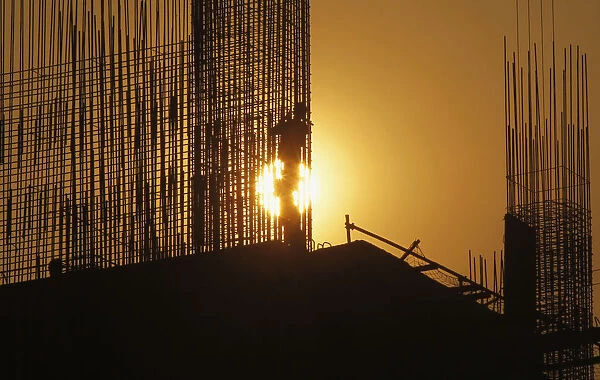 A worker arranges steel structures at construction site of apartment in Hanoi