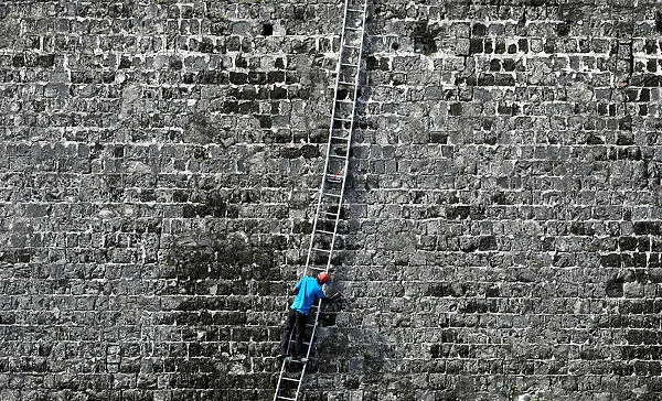 A worker cleans a wall at the Jaffna Fort, a fort built by the Portuguese in 1618