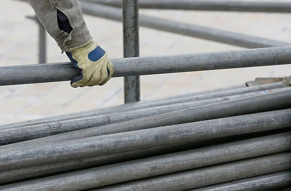 A worker holds a steel pipe as he works on the construction of a stage in central Kiev