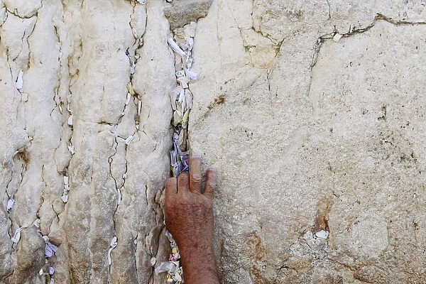 A worker removes notes from the cracks of the Western Wall in Jerusalems Old City