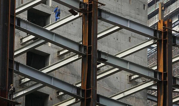 A worker walks on a steel girder at a building under construction in Nanjing