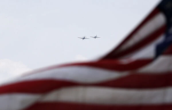 World War II era planes fly over U. S. flag during ceremony to commemorate the 70th